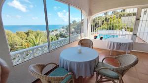 a room with two tables and chairs and the ocean at Casa Alberto - Altea in Altea