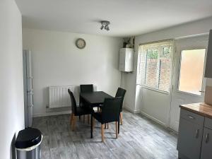 a dining room with a black table and chairs at Comfy Room in Nottingham in Nottingham