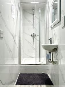 a white bathroom with a shower and a sink at Comfy Room in Nottingham in Nottingham