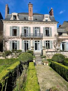 una gran casa blanca con una escalera delante de ella en Belle Fontaine en Bourges