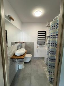 ein Badezimmer mit einem Waschbecken, einer Badewanne und einem WC in der Unterkunft STARA KAMIENICA in Reszel
