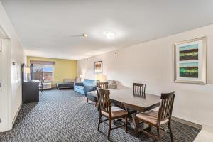 - un salon avec une table, des chaises et un canapé dans l'établissement Country Inn & Suites by Radisson, South Haven, MI, à South Haven