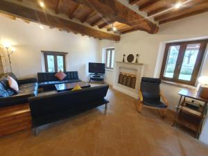 a living room with a black couch and a fireplace at Villa Lisabetta in Montecchio