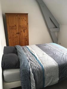 a bedroom with a bed and a wooden door at Appartement cosy Pleine Fougères in Pleine-Fougères