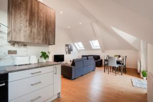 a kitchen and living room in an attic at Refined Living: Three Bedrooms Flat in Coulsdon CR5 in Coulsdon
