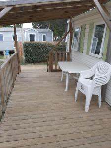 een veranda met een tafel en twee stoelen erop bij camping le novela in Port-la-Nouvelle