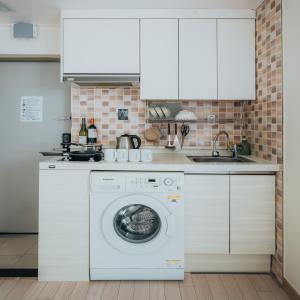 uma cozinha com uma máquina de lavar roupa e um lavatório em DK House em Seul