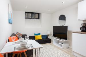 sala de estar con mesa y TV en One-Bedroom Apartment in Conditioning House, en Bradford