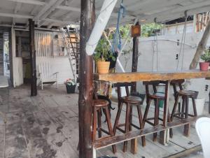 un viejo bar con taburetes en un porche en Hostel Ichtus, en Playa Blanca