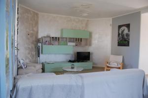 een woonkamer met een bed en een televisie bij Monferrato Asti-luminosa villa in CastellʼAlfero