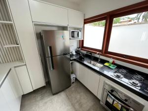 a kitchen with a stainless steel refrigerator and a window at Casa Maritaca in Paraty +5 photos