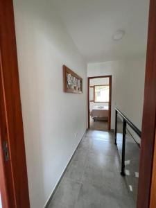 a hallway with white walls and a stair case at Casa Maritaca in Paraty