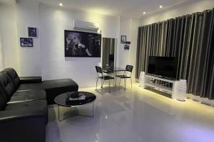 a living room with a couch and a table and a television at Sheryll Updates - Kandi T2 breezy 1BR on 9th floor with Housekeeping & Netflix in Angeles