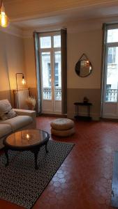 een woonkamer met een bank en een tafel bij Grand duplex calme - centre historique - 100m des Allées P. Riquet in Béziers