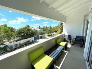 a balcony with two green chairs and a window at New* Tropical Modern Townhouse in SXM in Simpson Bay