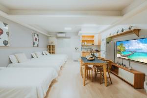 ソウルにあるDK Houseのベッドルーム1室(ベッド2台、テーブル、テレビ付)