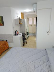 a bedroom with a white bed and a kitchen at CASA ZEUSI in Crotone