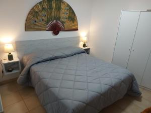 una camera con un letto e due lampade su due tavoli di CASA ZEUSI a Crotone