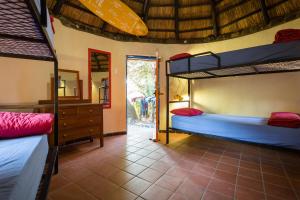 a room with two bunk beds and a mirror at Coffee Shack Adventure Backpackers & Self-Catering in Coffee Bay