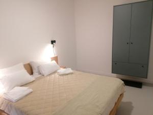 łóżko z białymi poduszkami i szafką w pokoju w obiekcie Vila Plava Zlatar w mieście Brdo