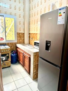 Il comprend une cuisine équipée d'un réfrigérateur en acier inoxydable. dans l'établissement Grandiose apart in yaounde, à Yaoundé
