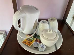 a plate with a tea kettle and containers on a table at Victoria's house in Kells