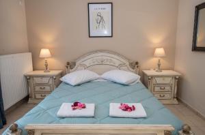 a bedroom with a blue bed with two night stands at John & Angelo Villa in Akrotiri