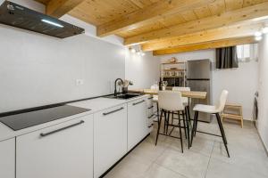 una cucina con armadi bianchi e soffitto in legno di New 2024 Urban 48 a Cagliari