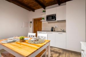 アルゲーロにあるC & C Holidaysのキッチン(木製テーブル、白いキャビネット付)