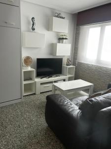 a living room with a couch and a tv at Estudio tipo Loft en el centro de Mugardos in Ares