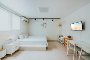 Un dormitorio blanco con una cama y un escritorio. en DK House, en Seúl