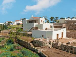 a large white house with a stone wall at Casa Kombonada in Kythira