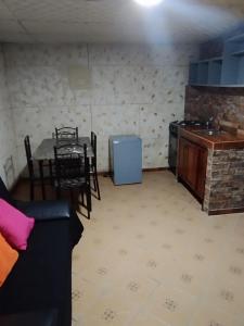 Cabaña de descanso في Alto Boquete: غرفة معيشة مع طاولة ومطبخ