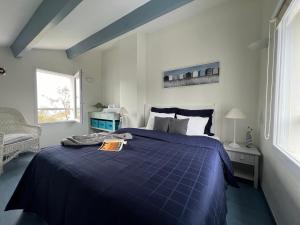 a bedroom with a blue bed and a window at Villa de la Cible in Saint-Martin-de-Ré