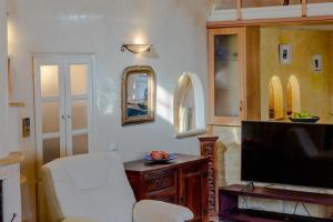 salon z telewizorem i białą kanapą w obiekcie Nasur w mieście Éxo Goniá