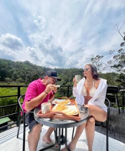 Um homem e uma mulher sentados à mesa a comer. em Gaia Elegancia Escarlata extra 2 em San Rafael