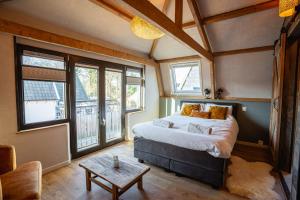 a bedroom with a bed in a room with windows at Het Droomatelier in Den Burg