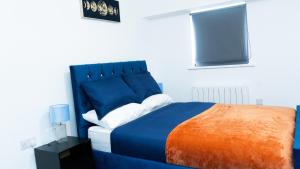 a blue bed with an orange and blue headboard in a room at 1BR Sleeps 4, 3 mins from City centre & Local Gems in Burton upon Trent