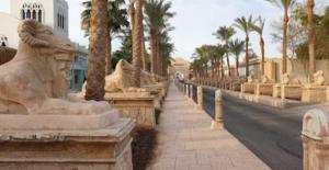 una fila di barriere in pietra su una strada con palme di شاليه داخل ميراج اكوا بارك a Hurghada