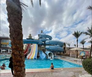 un tobogán de agua en una piscina de un complejo en شاليه داخل ميراج اكوا بارك en Hurghada