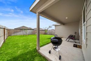 - un barbecue sur une terrasse à côté d'une cour dans l'établissement Sa Rancho La Mission Getaway Wi-fi Yard Bbq, à Elmendorf