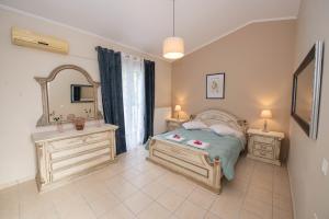 a bedroom with a bed and two dressers and a mirror at John & Angelo Villa in Akrotiri