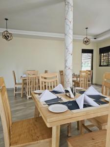 uma sala de jantar com uma mesa de madeira e cadeiras em Kaije Country Cottages em Fort Portal
