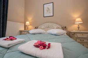a bedroom with two beds with pink roses on towels at John & Angelo Villa in Akrotiri