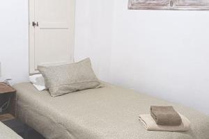 a bed with a pillow and a towel on it at Maison de charme 2 terrasses, en ville, mer, port. in Águilas