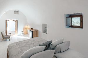 a white room with a bed with pillows at Casa Kombonada in Kýthira