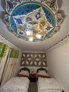 a room with two beds and a chandelier at Rizo Boutique in Bukhara