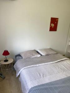 - une chambre avec un lit et une table avec une lampe dans l'établissement Villa Fusains, à Baie-Mahault