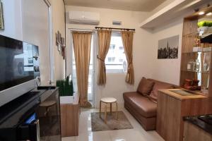 Televisi dan/atau pusat hiburan di Apt Green Pramuka 2BR Tower B With Wi-Fi and Pool by Damaresa