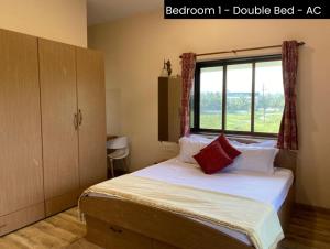 1 dormitorio con 1 cama y ventana en Nessies en Alibaug
